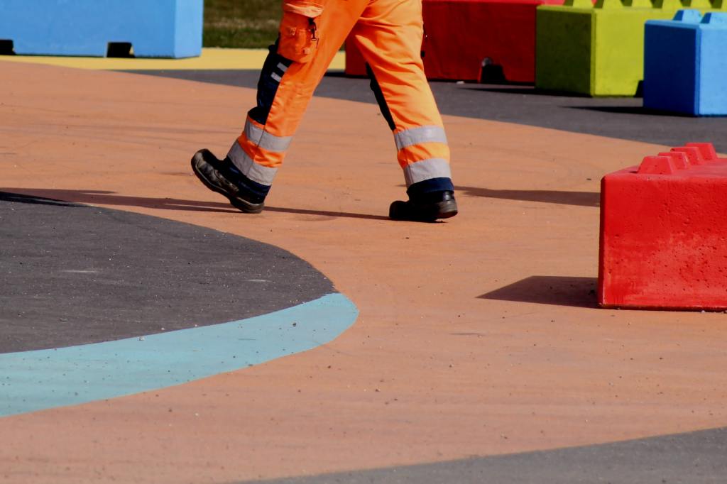Un uomo al lavoro vestito con abiti da lavoro e DPI