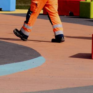 Un uomo al lavoro vestito con abiti da lavoro e DPI
