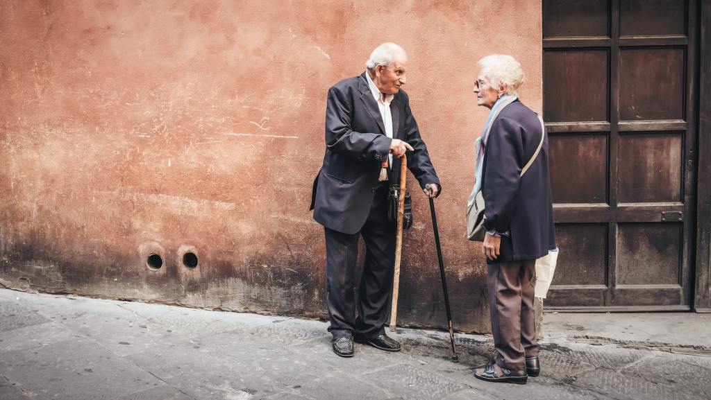 due persone anziane che parlano all'ingresso di una casa di riposo in Italia