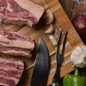 fetta di carne di maiale su un tagliere di legno con accanto le verdure