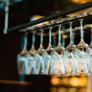 diversi bicchieri da vino appesi in una enoteca