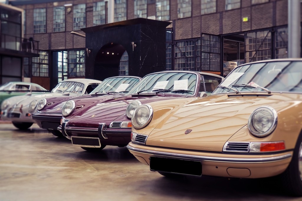 diversi veicoli d'epoca parcheggiati davanti a un garage