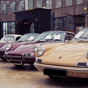 diversi veicoli d'epoca parcheggiati davanti a un garage
