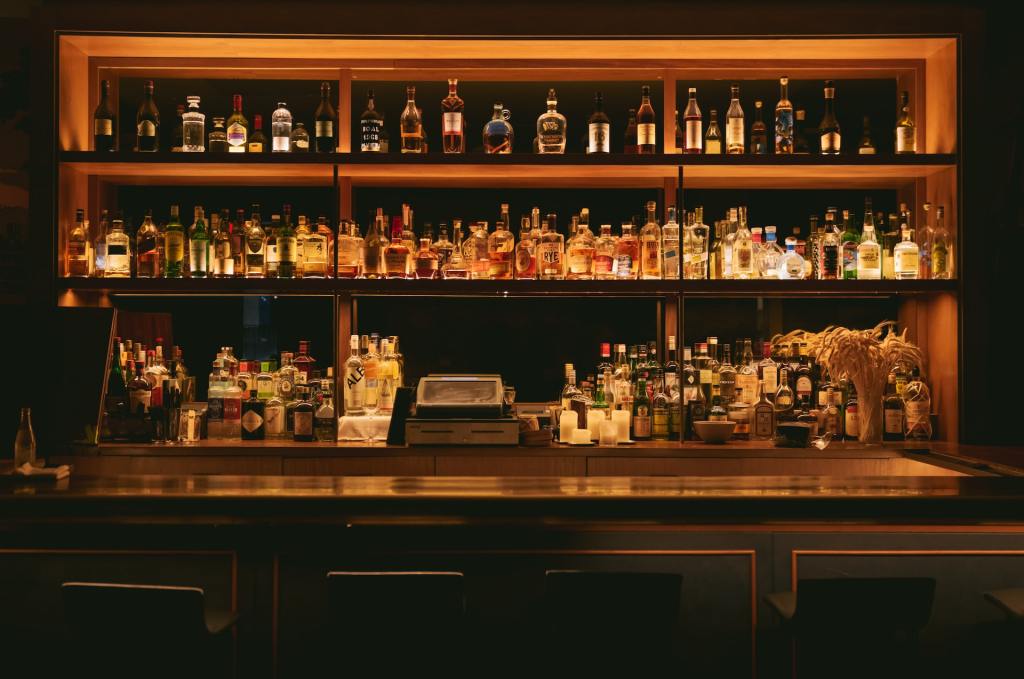 diversi tipi di distillati esposti sugli scaffali di un bar in Italia