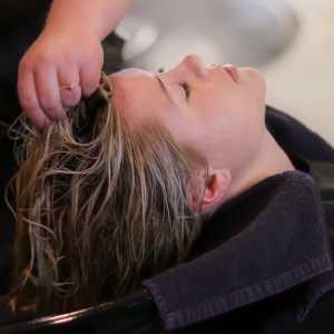 donna in un salone di parrucchieri che si fa lavare i capelli con prodotti per la cura dei capelli
