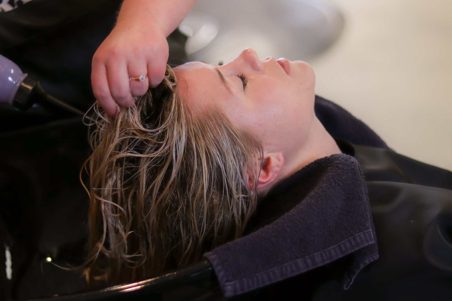 donna in un salone di parrucchieri che si fa lavare i capelli con prodotti per la cura dei capelli