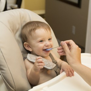 bambino a cui viene dato un cucchiaio durante il pasto