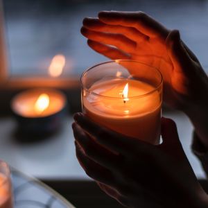 una persona che tiene in mano una candela profumata