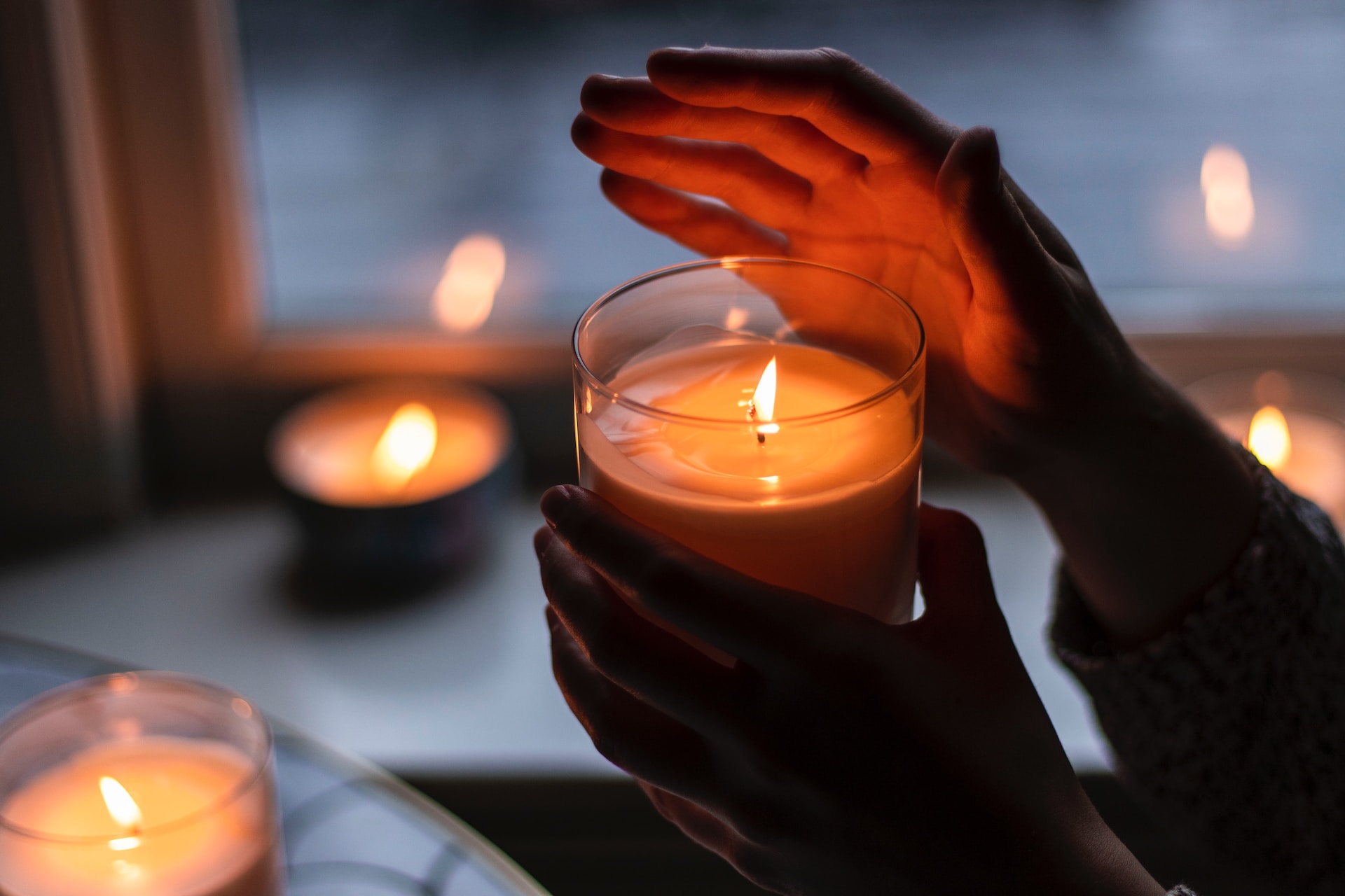 una persona che tiene in mano una candela profumata