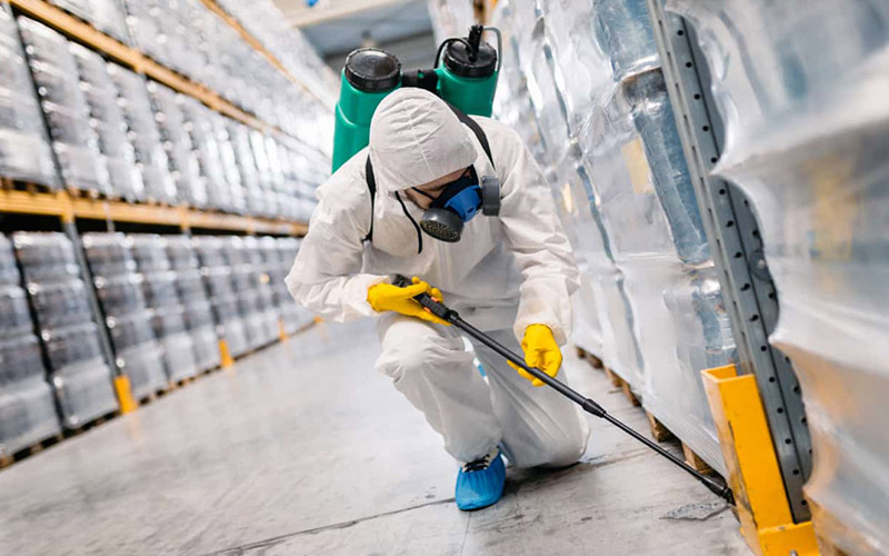 lavoratore che disinfetta e disinfetta un magazzino