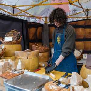un giovane venditore di formaggio in un banco